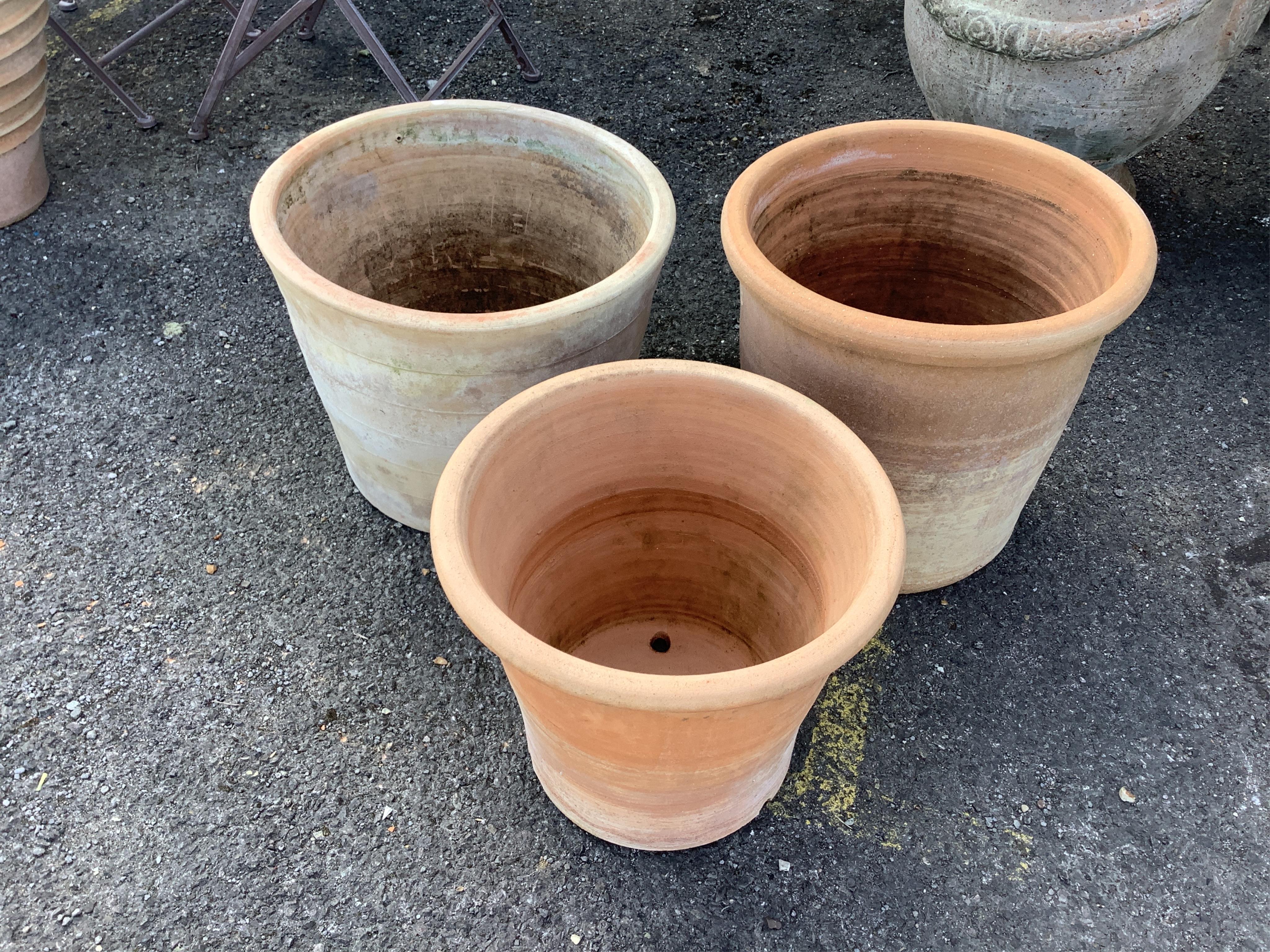 Three circular terracotta garden planters, largest diameter 44cm, height 35cm